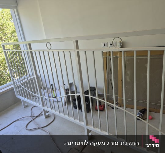 מעקה מתכת לבן מותקן במרפסת